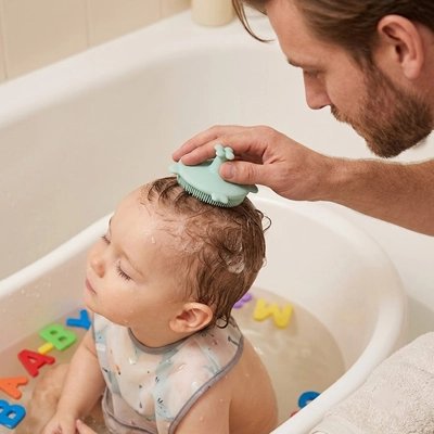 Brosse cheveux bebe dans les mains de papa