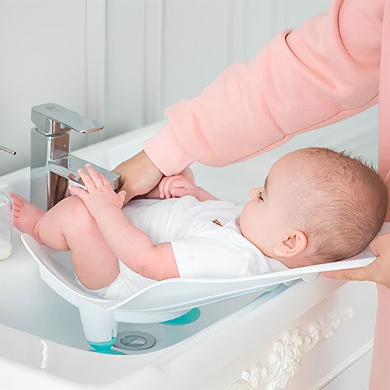 Siege de bain bebe vert au lavabo avec sécurité